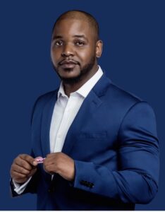 Rahkim Sabree, a man of color in a white collared shirt and blue blazer with a blue background.
