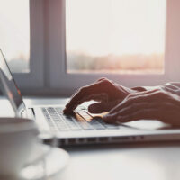 Businessman or student using laptop at home, Man hands typing on computer keyboard closeup, business. online learning, internet marketing, working from home, office workplace, freelance concept