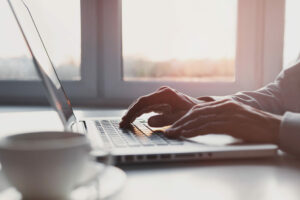 Businessman or student using laptop at home, Man hands typing on computer keyboard closeup, business. online learning, internet marketing, working from home, office workplace, freelance concept