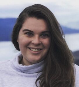 light background, white women with long brown, wavy hair, white turtleneck